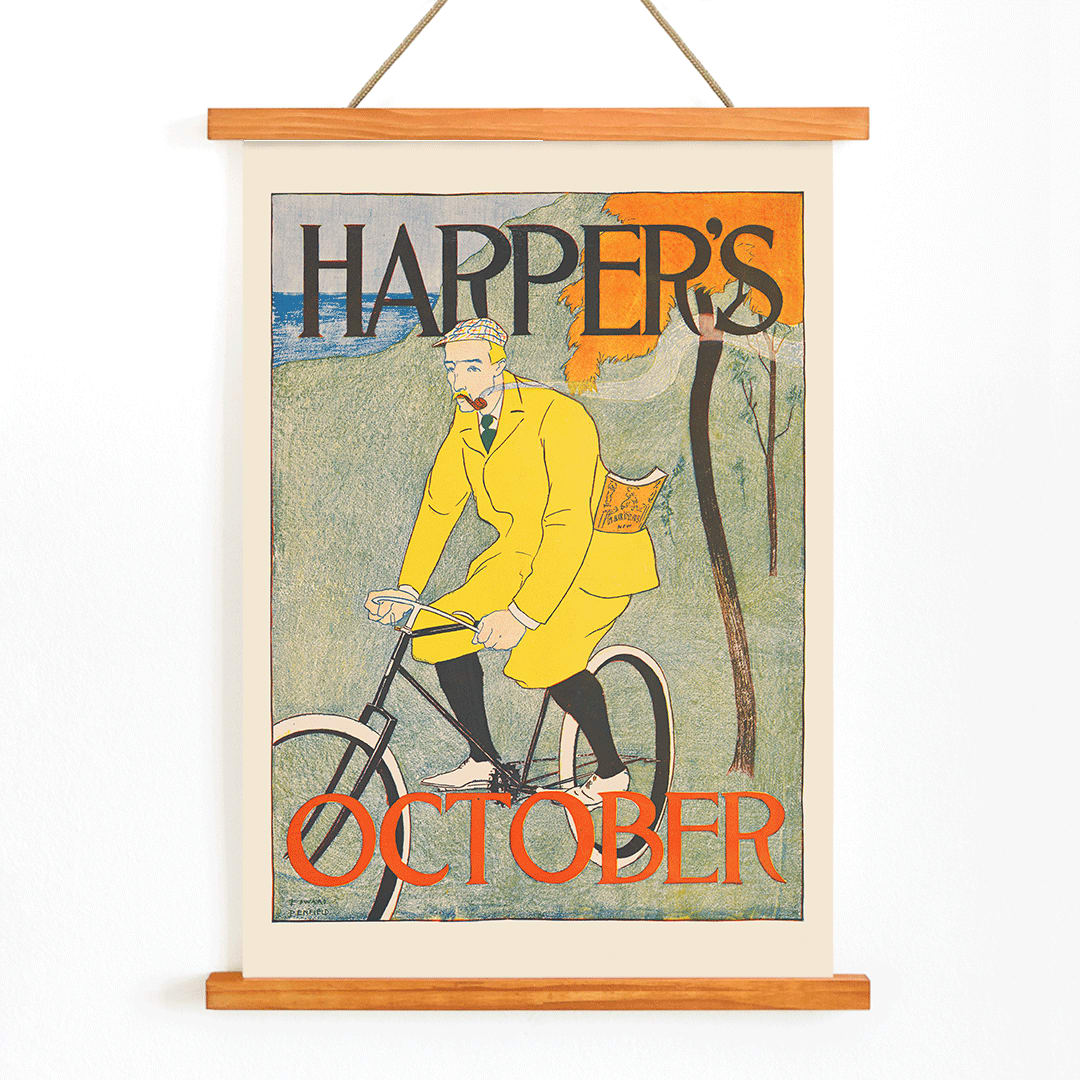 Man riding bicycle in autumn landscape wearing yellow outfit Harper for October poster by Edward Penfield with title displayed at top and bottom, with wooden magnetic frame on white background
