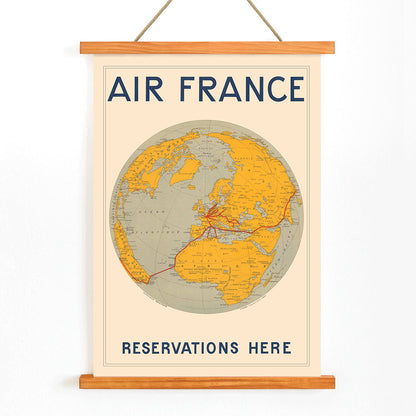 Vintage Air France travel poster by E Giraud showing world map with airline routes highlighted in red, with wooden magnetic frame on white background