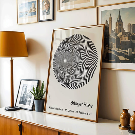 Bridget Riley Blaze Exhibition Poster featuring hypnotic black and white spiral geometric design on light background, framed and displayed in home decor
