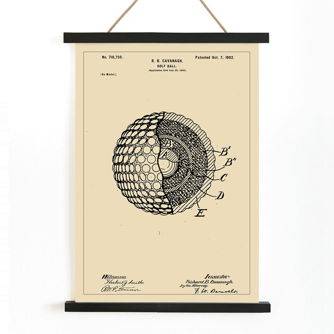 Golf ball patent technical drawing by R B Cavanagh showing detailed labeled interior structure and design elements, with wooden magnetic frame on white background