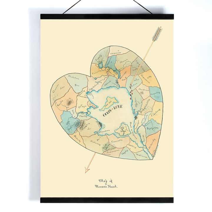 Joseph Husson Map of a Womans Heart 2 poster featuring a heart shaped map with an arrow, soft pastel blue and beige details, vintage style, with wooden magnetic frame on white background
