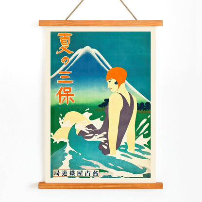 Japanese woman in bathing suit with orange cap sitting in waves at Miho Peninsula with Mount Fuji in background by Nagoya Rail Agency, with wooden magnetic frame on white background