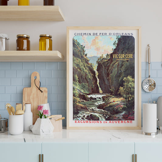 Scenic mountain gorge with river and footbridge in Vic Sur Cere travel poster by Louis Tauzin artwork for excursions in Auvergne, framed and displayed in home decor
