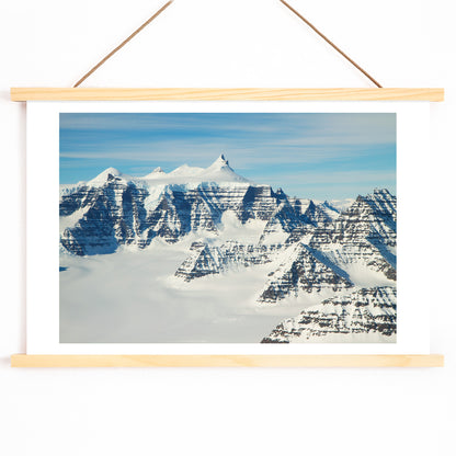 Snow covered mountain ridges and unique geology of the Geikie Plateau eastern Greenland by NASA poster, with wooden magnetic frame on white background