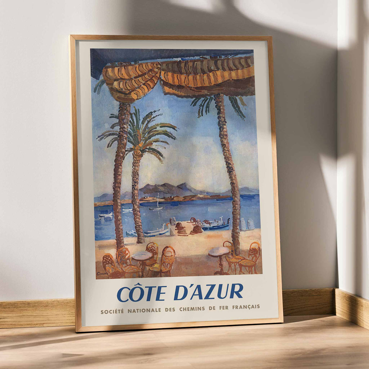 Edmond Céria French Riviera Railway poster with palm trees, blue sea, sandy beach, ochre canopies, vintage travel style, with wooden magnetic frame on white background