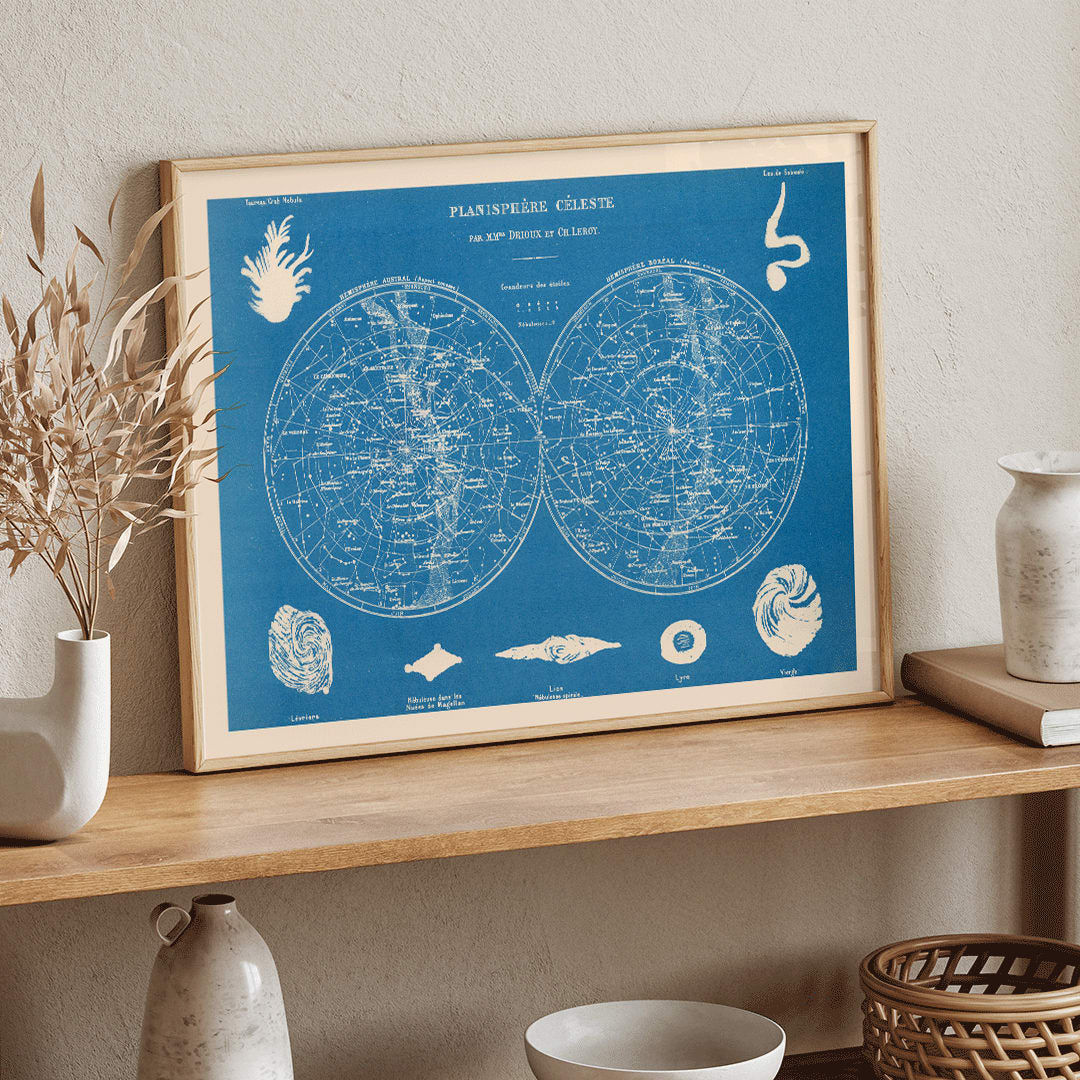 Celestial planisphere star map poster by Claude Joseph Drioux featuring constellations and astronomical illustrations on blue background, framed and displayed in home decor