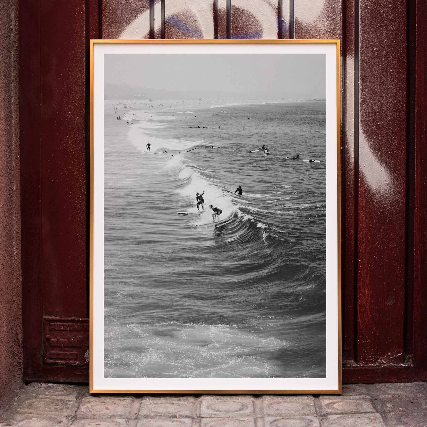 Black and white surfers riding waves at Venice Beach coastal wall art poster ideal for home decor, framed and displayed in home decor