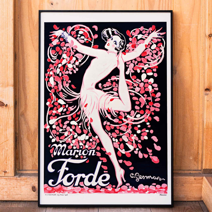Art Deco poster of Marion Forde by Charles Gesmar featuring a dancer in a pink dress surrounded by vibrant swirling petals, framed and displayed in home decor