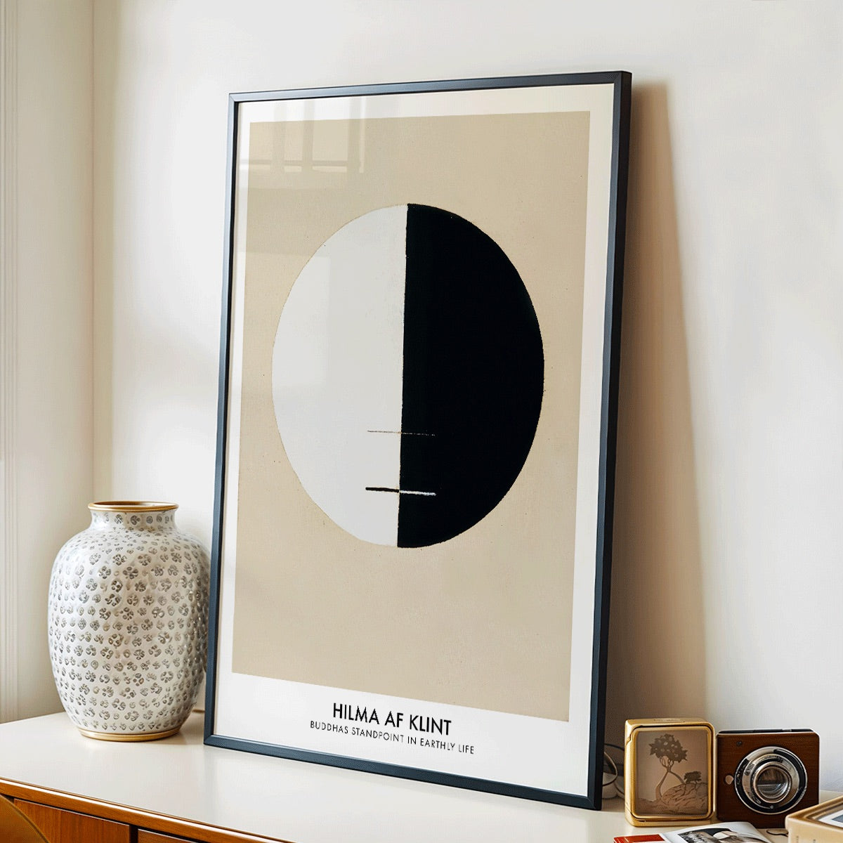 Black and white circle artwork poster Buddha Standpoint In Early Life by Hilma AF Klint with divided circle on beige background, framed and displayed in modern living room decor