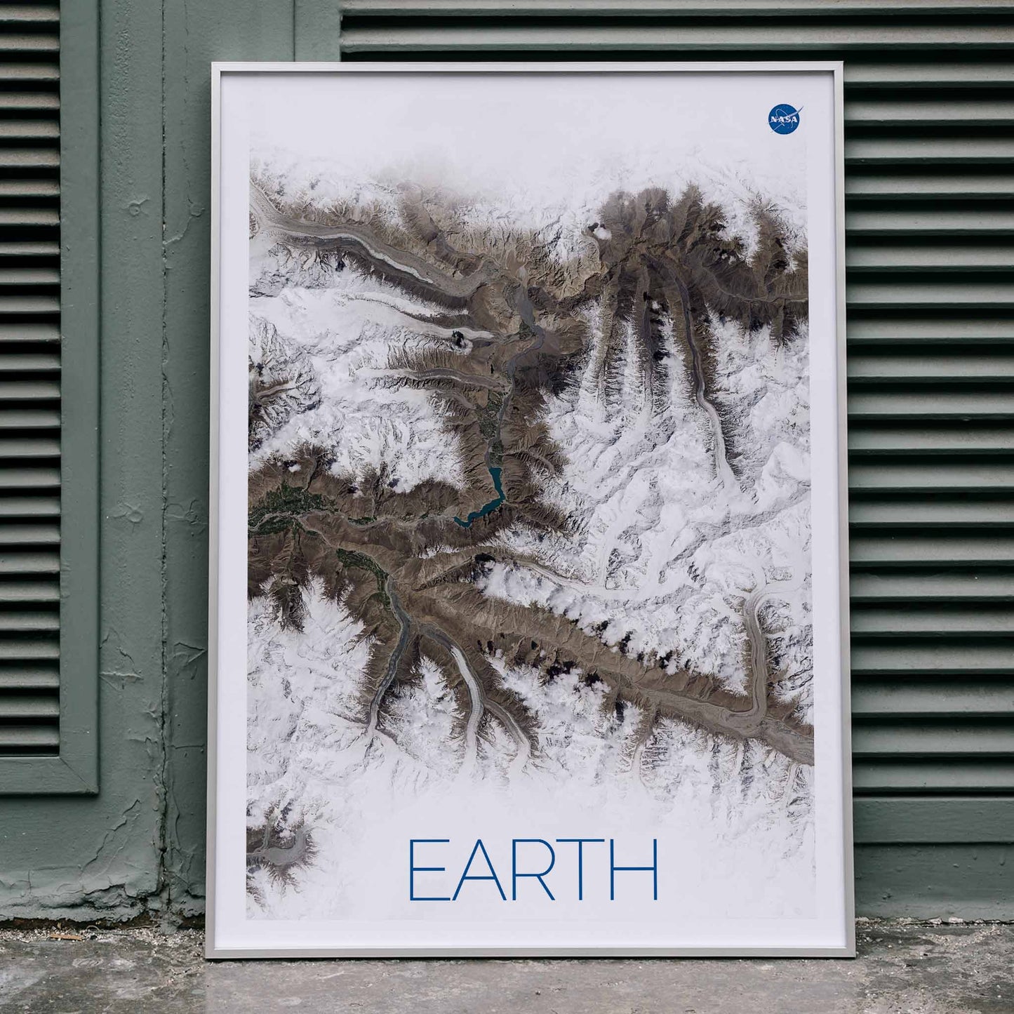 Stunning NASA satellite image of Earth showing snowy mountain ranges and rugged terrain high resolution poster, framed and displayed in home decor