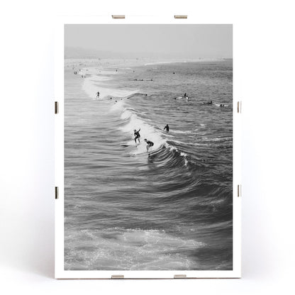 Black and white surfers riding waves at Venice Beach coastal wall art poster ideal for home decor, framed and displayed in modern living room decor