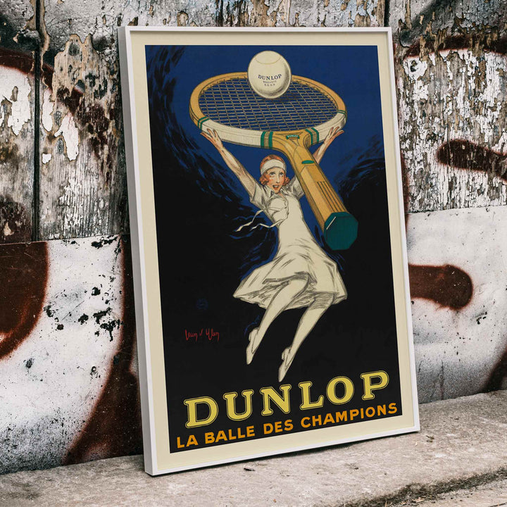 Jean dYlen Dunlop The Ball of Champions poster with leaping tennis player giant racket and ball in bold blue and black, framed and displayed in home decor