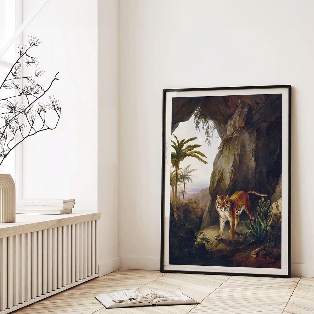 Tiger in a Cave painting by Jacques Laurent Agasse showing a tiger standing in a cave entrance surrounded by lush vegetation, framed and displayed in home decor